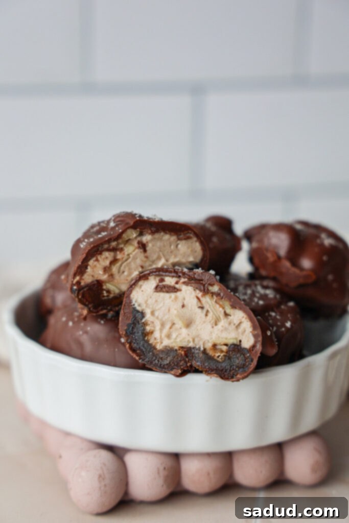 Peanut Butter Cheesecake Date Bombs 2 A bowl of peanut butter cheesecake stuffed dates, covered in chocolate and sprinkled with sea salt.