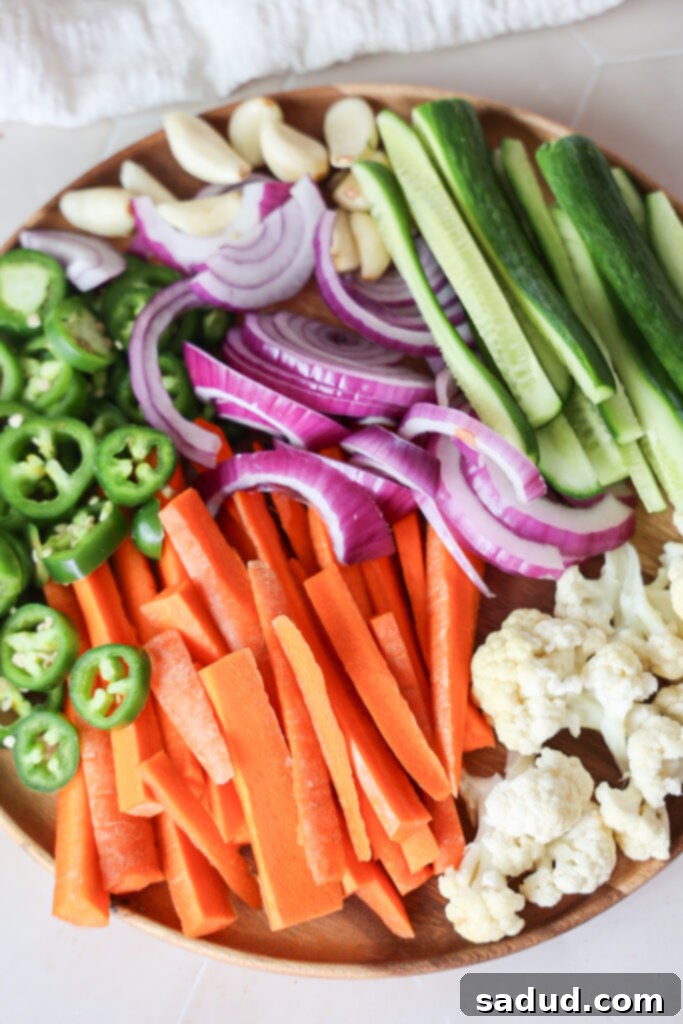 A plate filled with an assortment of chopped vegetables ready for pickling, including carrots, cucumbers, and red onions.