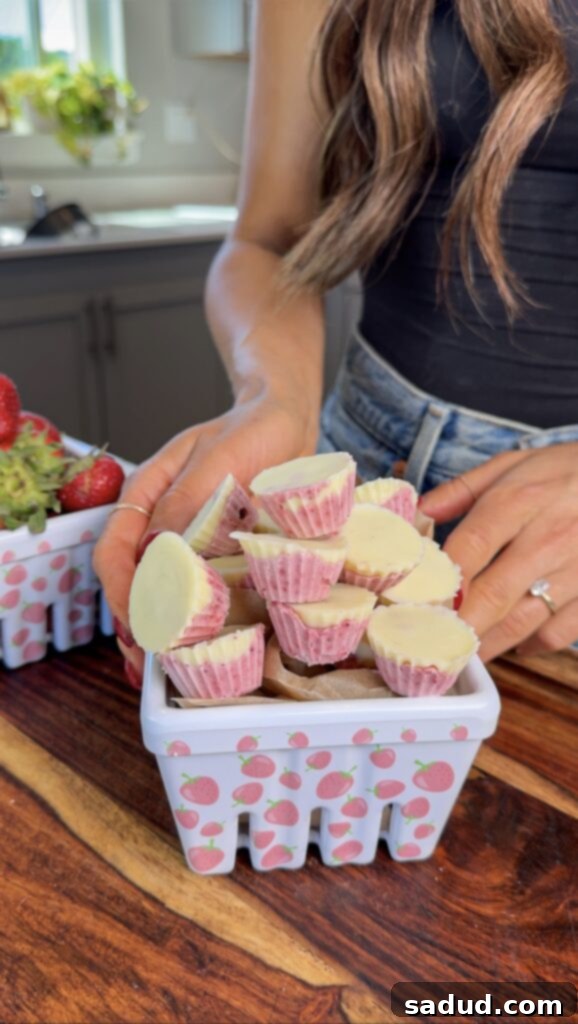 A close-up of a perfectly formed strawberry yogurt cluster, ready to be dipped in chocolate.