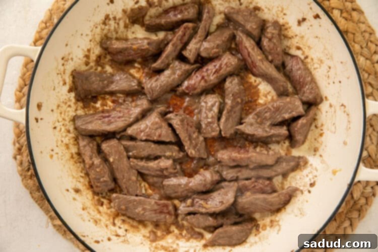 Beef strips in large bowl coated with cornstarch