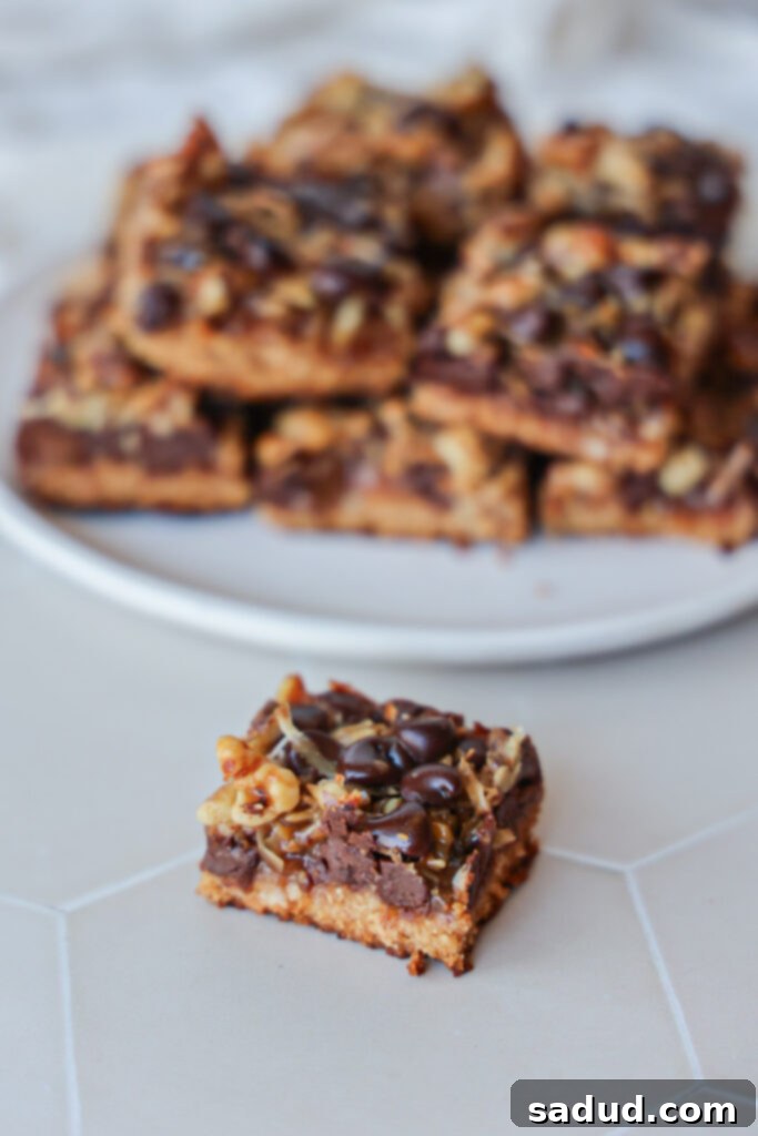 Close-up of the delicious layers in healthy Magic Cookie Bars, showing the toasted coconut, chocolate, and caramel over the cookie base.