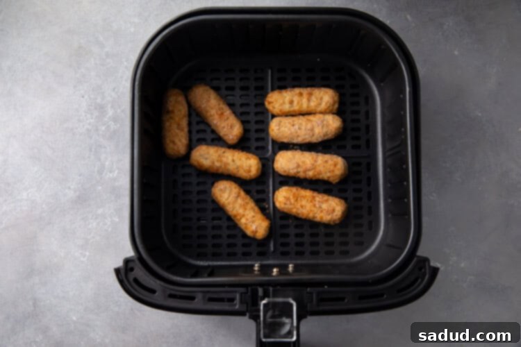 Frozen mozzarella sticks in an air fryer basket