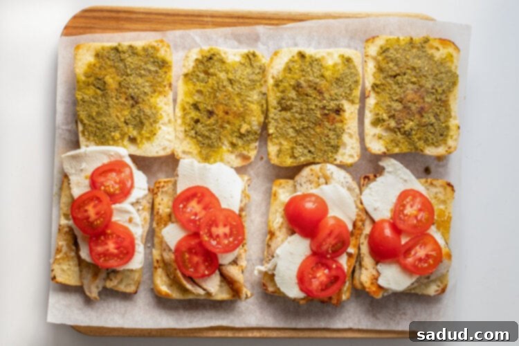 Tomato slices on top of mozzarella and chicken cutlets on ciabatta rolls.
