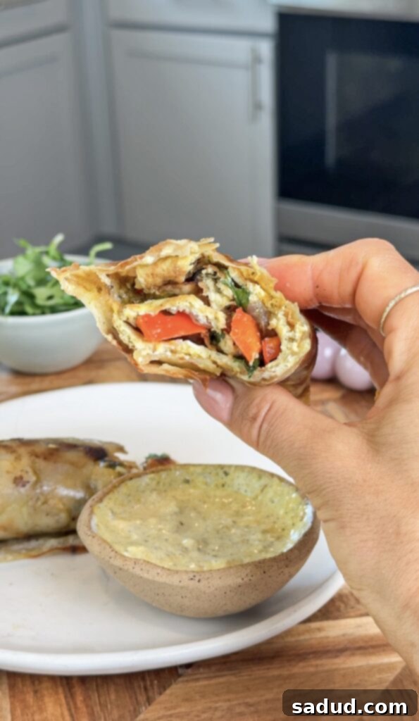 Delicious and healthy breakfast burrito with potato wrap, showing a cross-section of the filling.