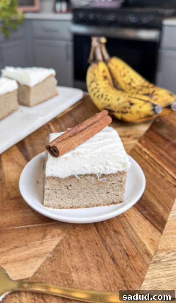 Healthy banana bread bars with creamy frosting and a sprinkle of cinnamon on a plate.