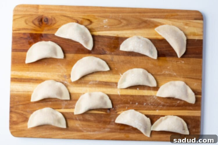 Closed and sealed chicken gyoza on a cutting board