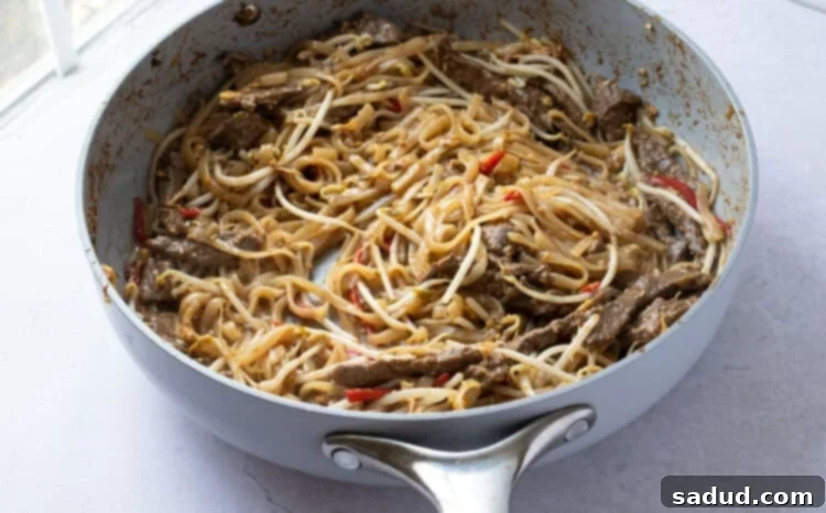 Beef pad thai with bean sprouts in large skillet
