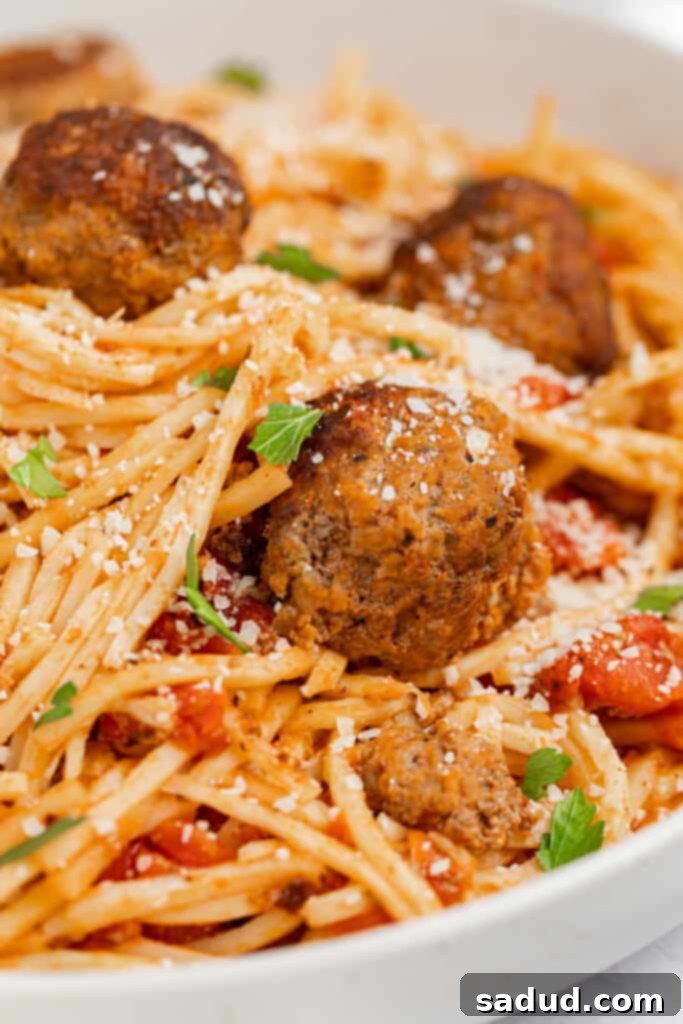Ultimate Keto Spaghetti and Meatballs 2 Close up image of keto spaghetti and meatballs with parmesan cheese and parsley on top.