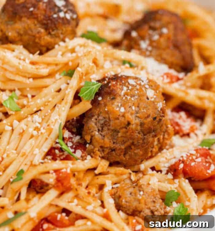 Ultimate Keto Spaghetti and Meatballs 4 A plate of delicious keto spaghetti and meatballs garnished with fresh parsley and parmesan cheese.