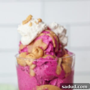 A bowl of Dragon Fruit Ice Cream with Peanut Butter Magic Shell and Cookie Dough