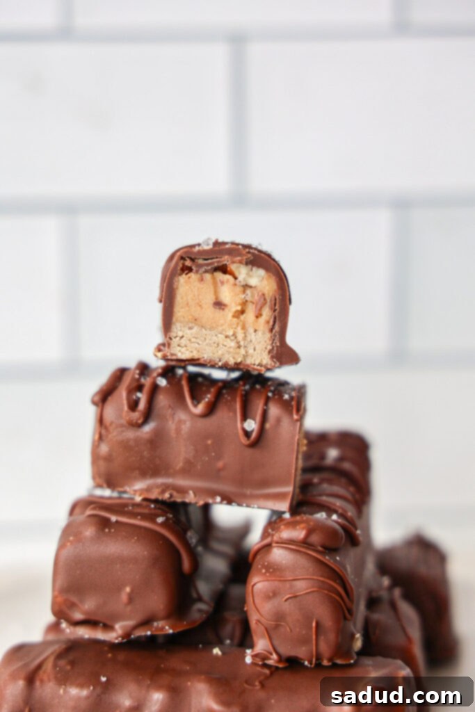 High Protein No Bake Healthy Pecan Snickers 2 A stack of healthy no-bake, vegan Snickers bars with pecans, showing the layers.
