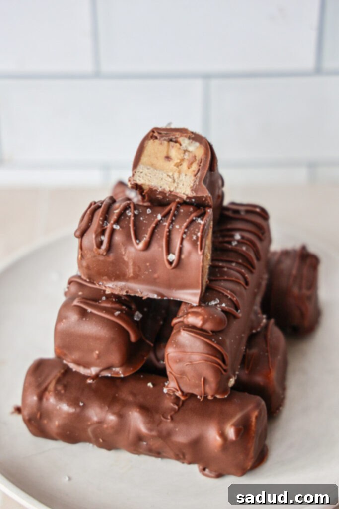 High Protein No Bake Healthy Pecan Snickers 4 A stack of healthy vegan, no-bake snickers bars with pecans and chocolate, ready to eat.