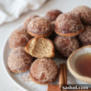 Paleo Pancake Poppers 4 A Plate of cinnamon sugar pancake puffs with maple syrup drizzled over them.