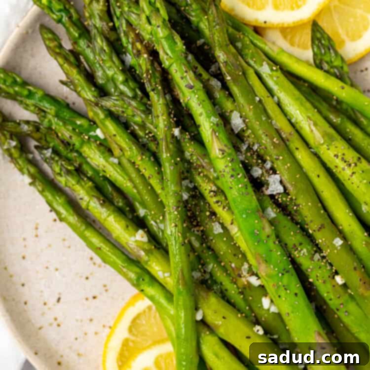 Asparagus on a plate with lemon slices.