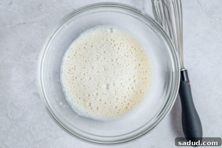 Almond milk and cornstarch slurry in glass mixing bowl.