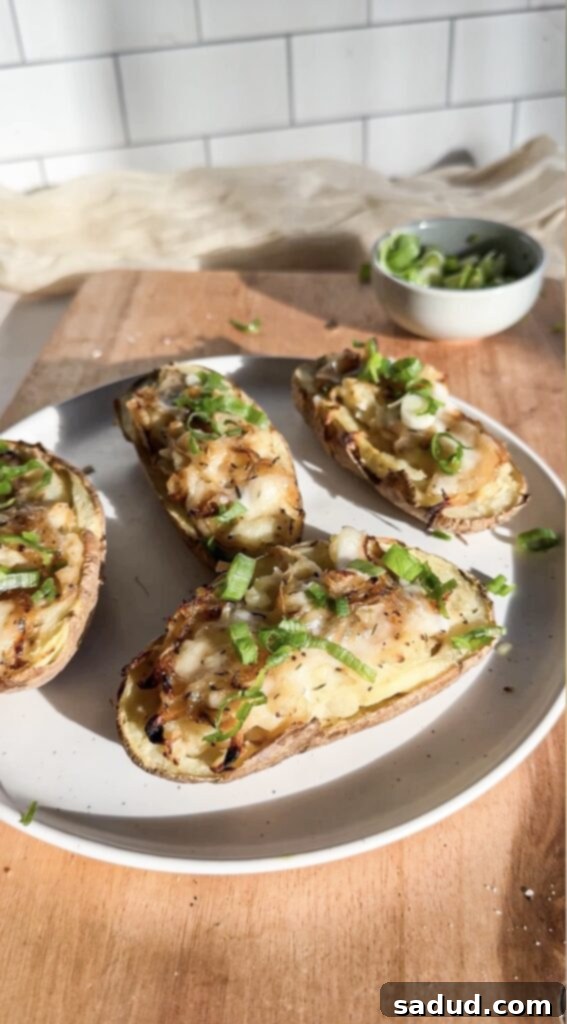 A plate of French onion twice baked potatoes, garnished with fresh herbs.