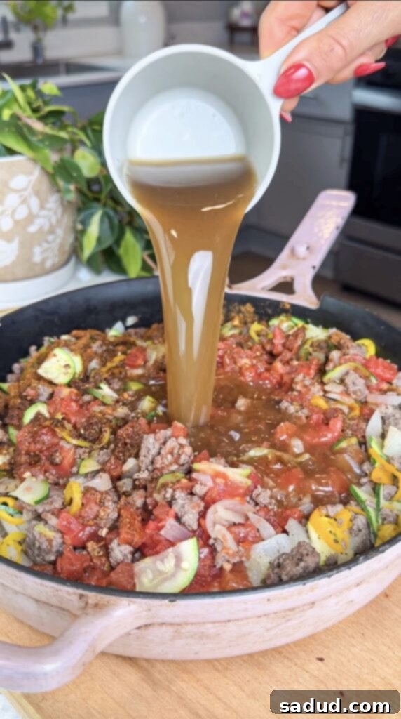Chili and cornbread casserole cooking in a skillet, demonstrating the one-pot method.