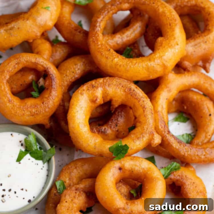 Crispy Gluten-Free Onion Rings 4 Gluten free onion rings on a plate next to a small dipping bowl of ranch dressing
