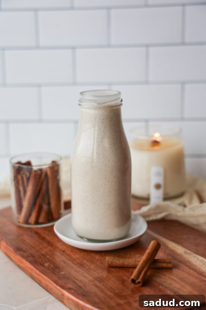 Creamy Vegan Eggnog Perfection 2 Healthy vegan eggnog served in a glass with a cinnamon stick and star anise.
