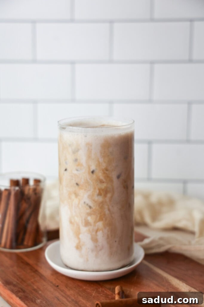 Creamy Vegan Eggnog Perfection 7 Two glasses of vegan eggnog with holiday decorations, a gift and a wreath.