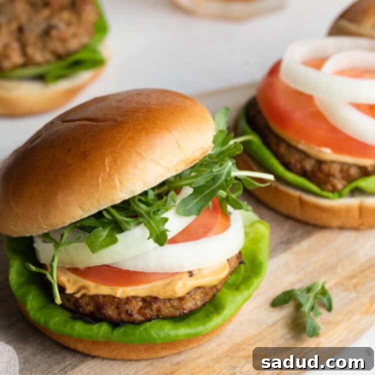 Three air fryer turkey burgers perfectly cooked, served on buns with fresh toppings, alongside refreshing drinks.
