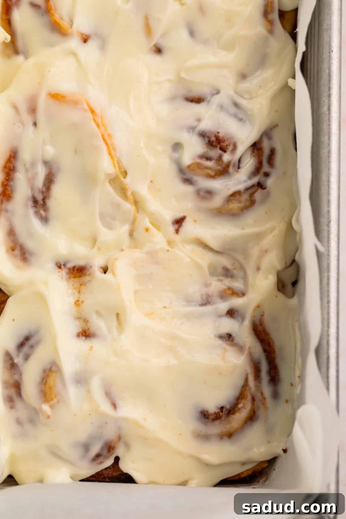 Overhead shot of frosted cinnamon rolls in the pan.